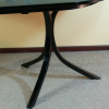 Close up photo of the dining-poker table's curved tripod legs 