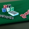 Close up photo of the green felt playing surface with cards and poker chips